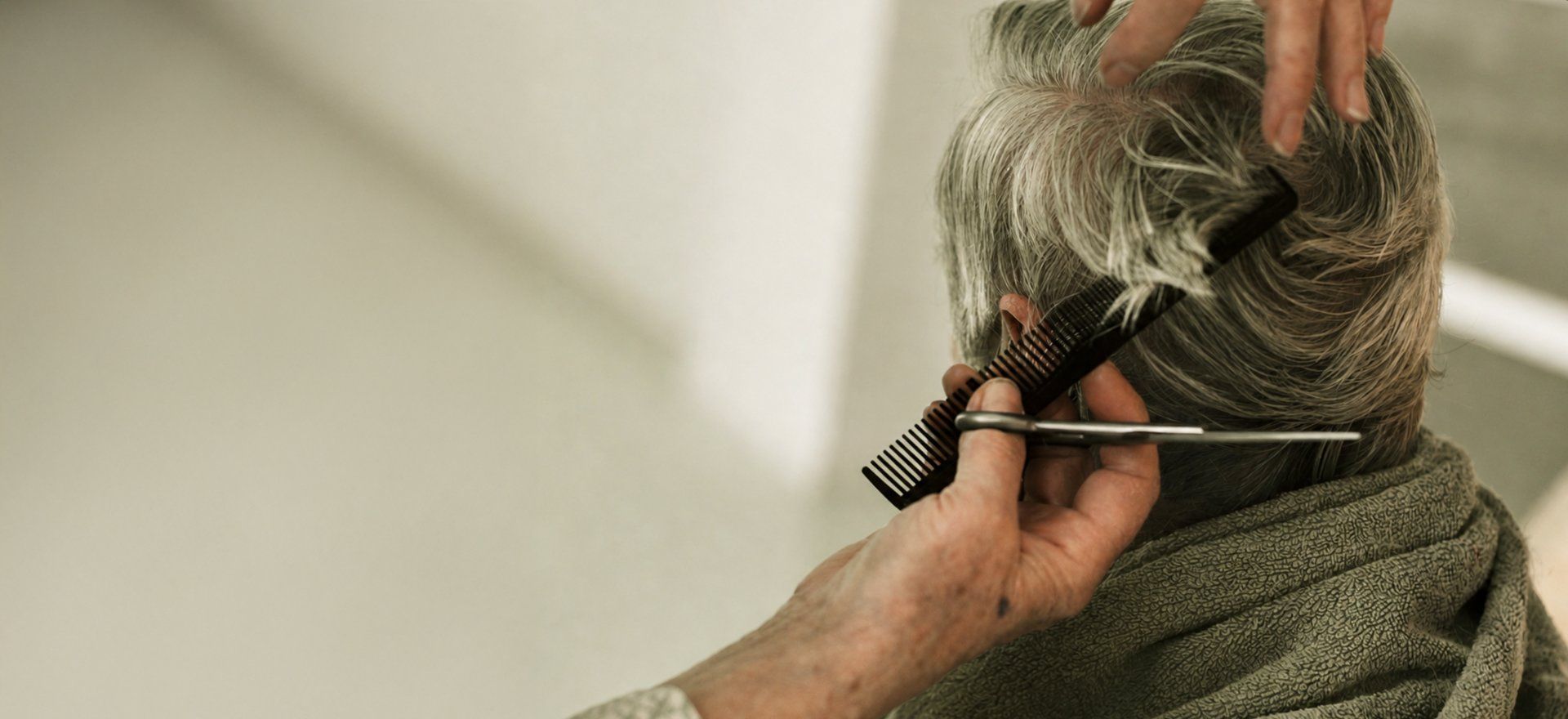 A barber trimming a customer's hair