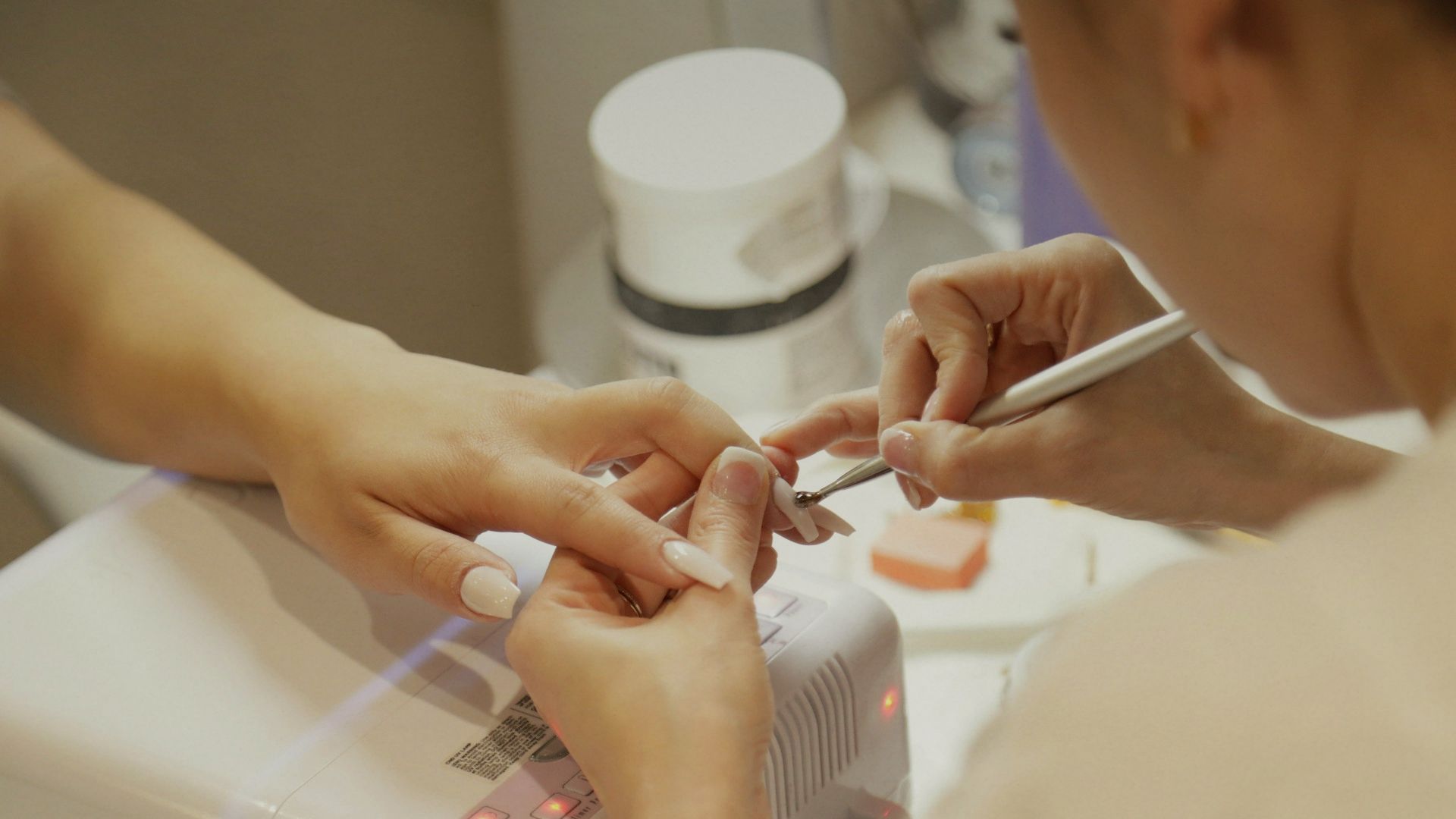 A nail technician polishing a customer's nails